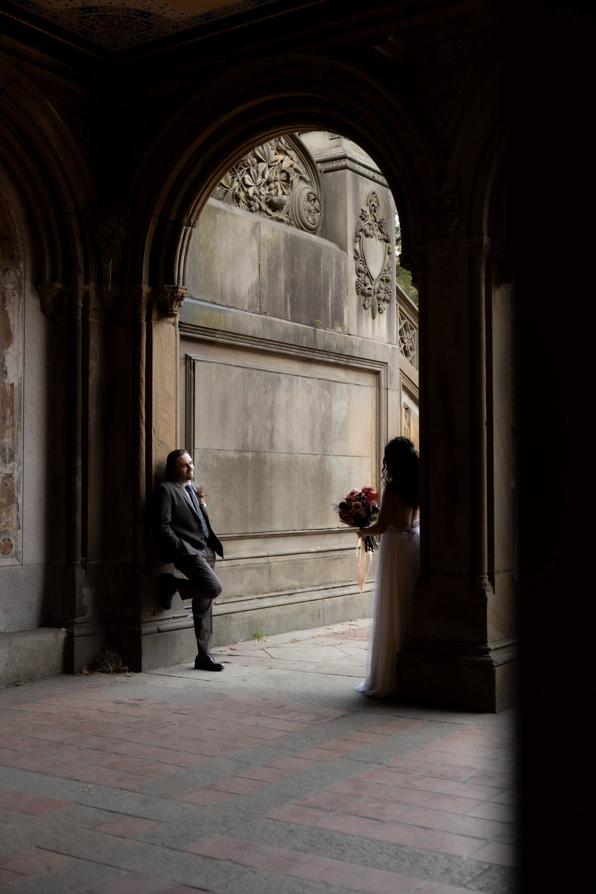 The couple sharing a tender moment beneath Central Park’s beautiful stone arches.