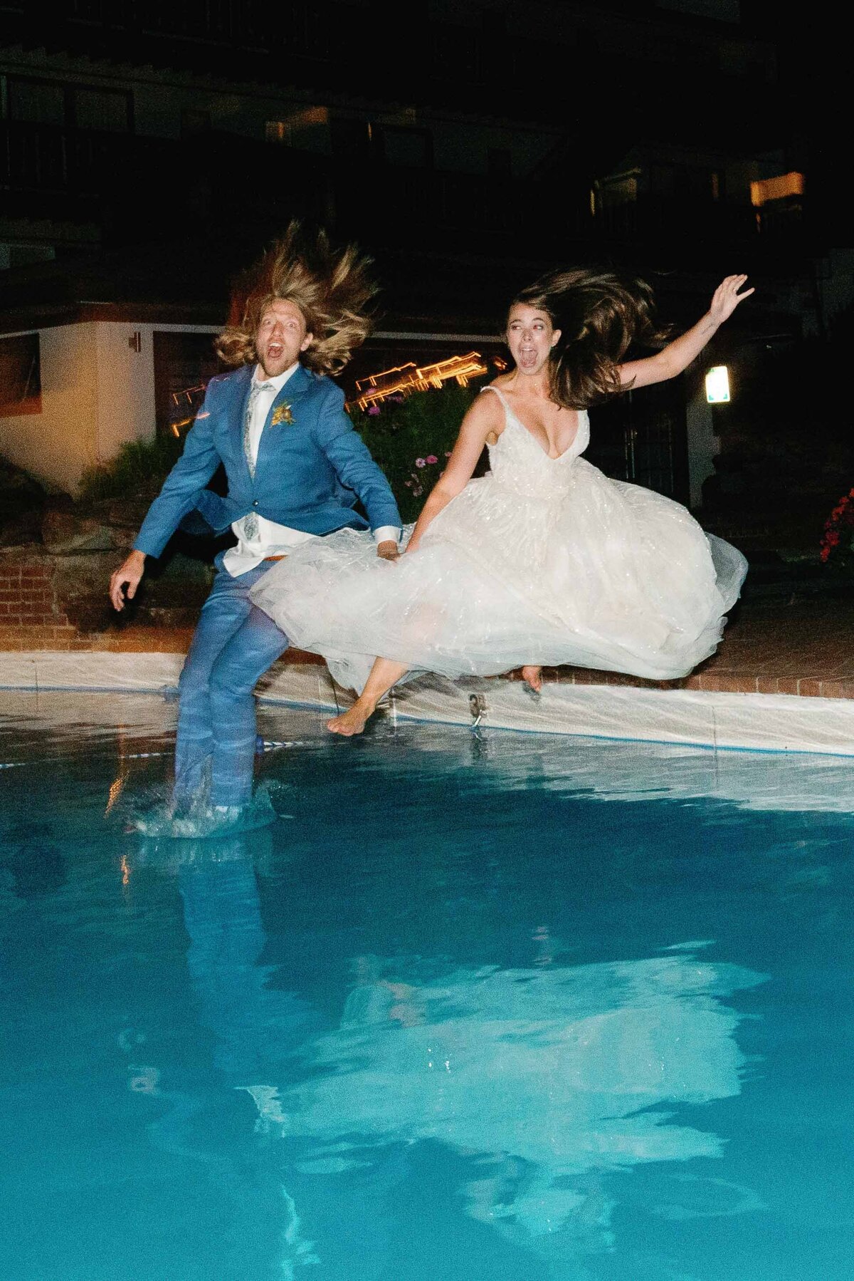 bride and groom jump into pool at stowehof by lindsey leichthamer events