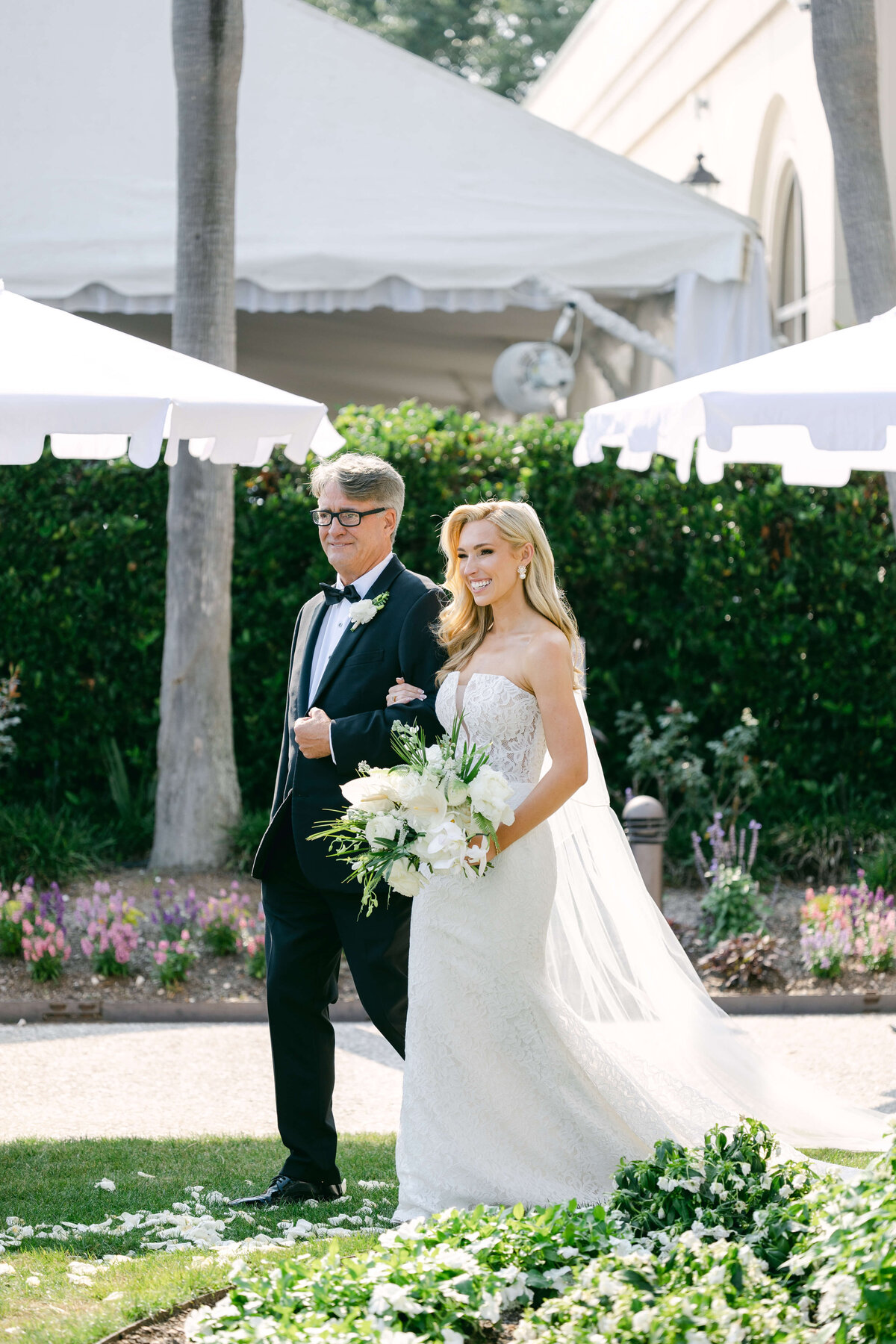 A bride walks with her father.