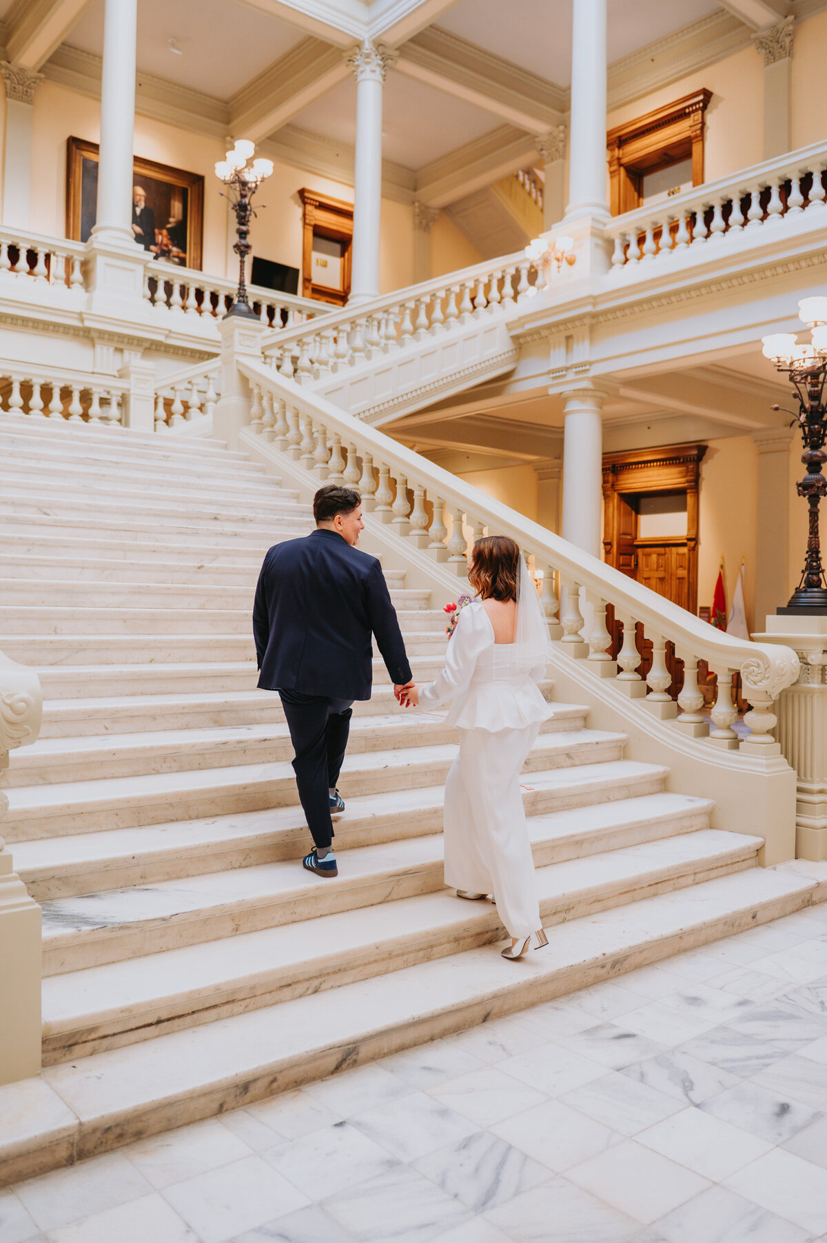 Two people walk up white steps at a courthouse