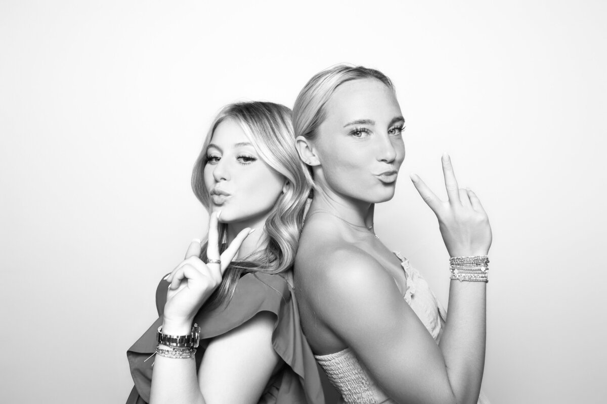 two ladies pose with peace signs for their celebrity photo booth picture