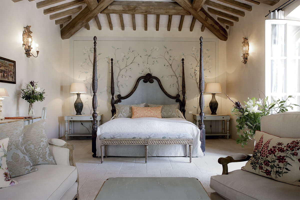 A four-poster canopy bed at Borgo Santo Pietro with chinoiserie wallpaper and exposed beam ceilings