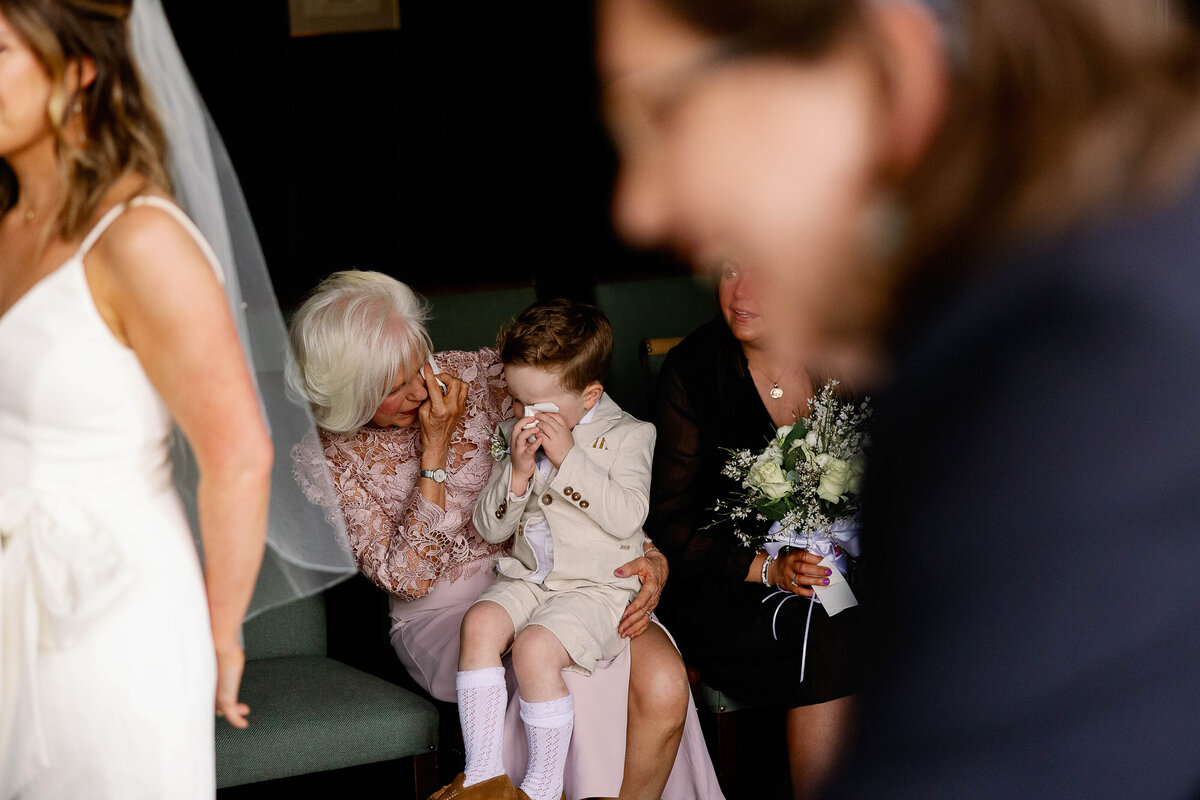 Paige boy wiping away tears as his parents exchange wedding vows