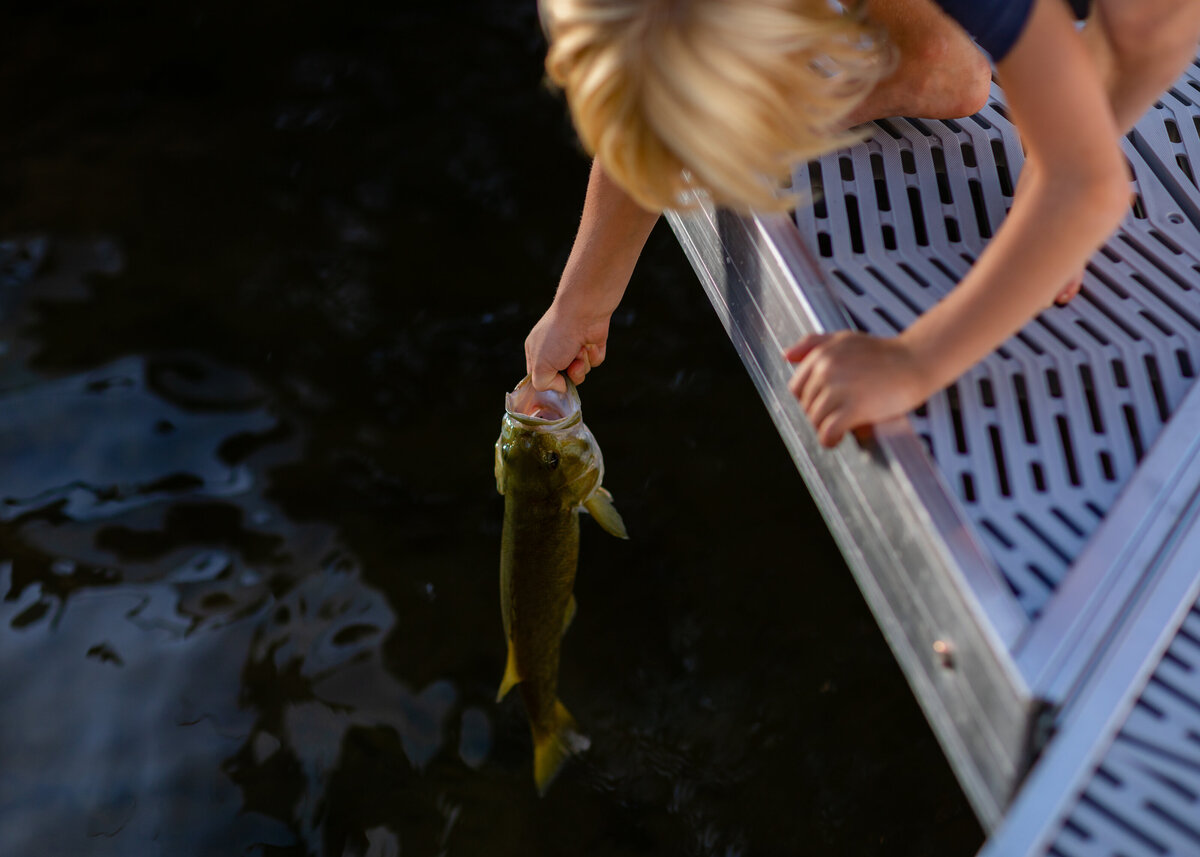 child-releases-fish-lake