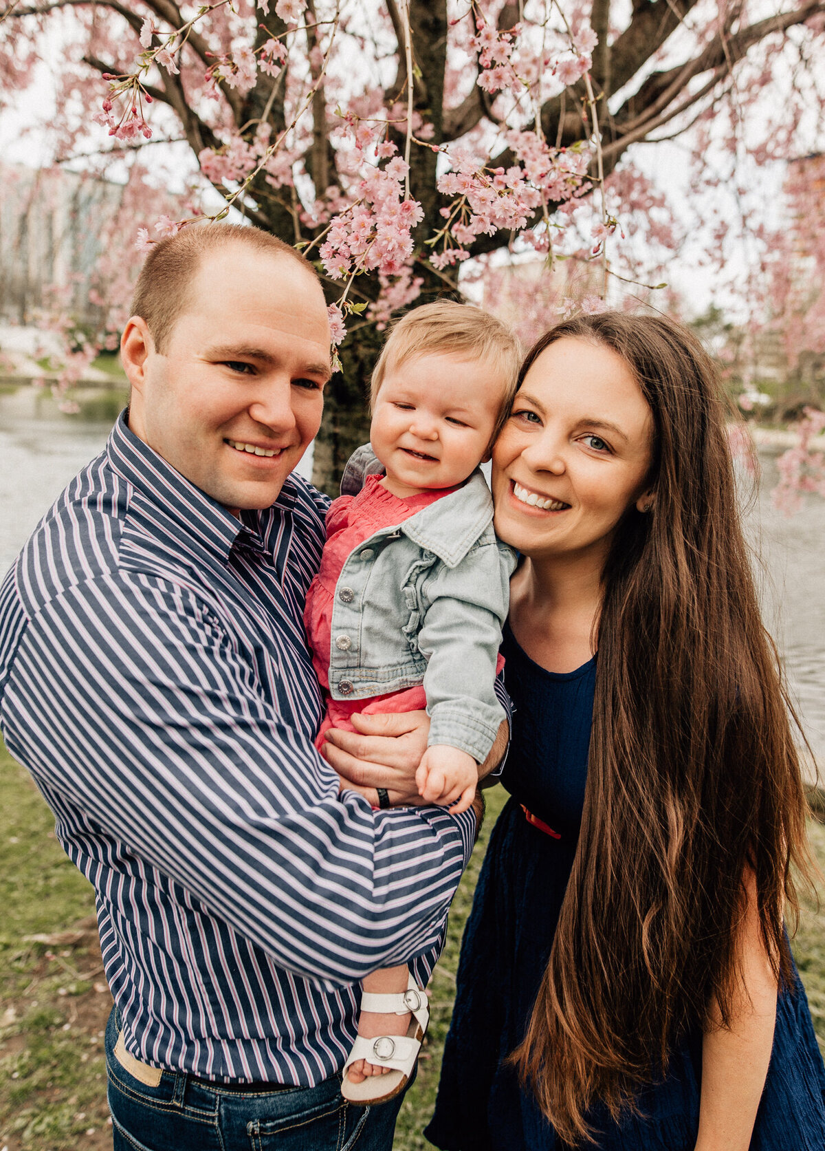 Family photo of mom, dad, and young baby.