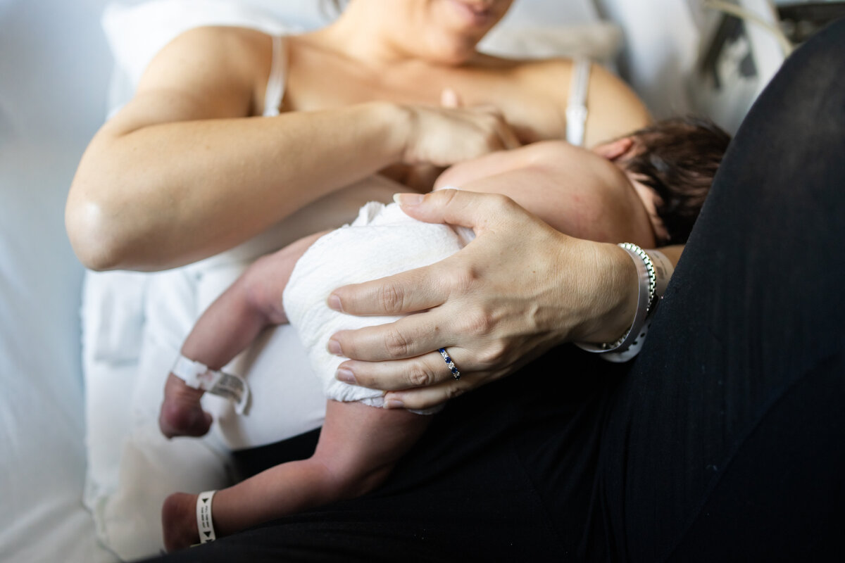 Mom cradling newborn while he nurses