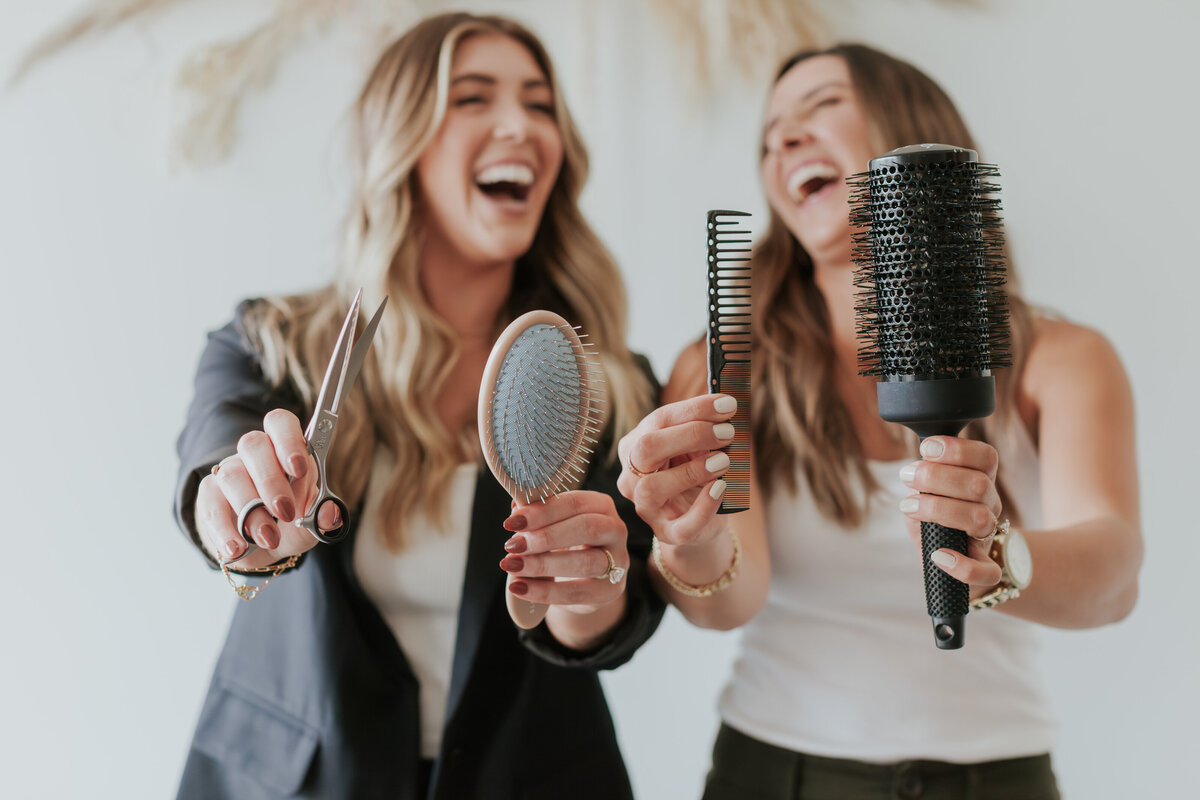 female-hairstylists-laughing-holding-hair-tools-for-brand-session-sout-charlotte