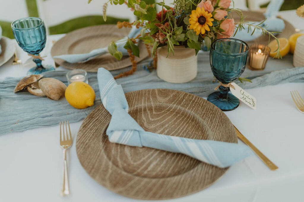 Wood chargers with dusty blue napkins
