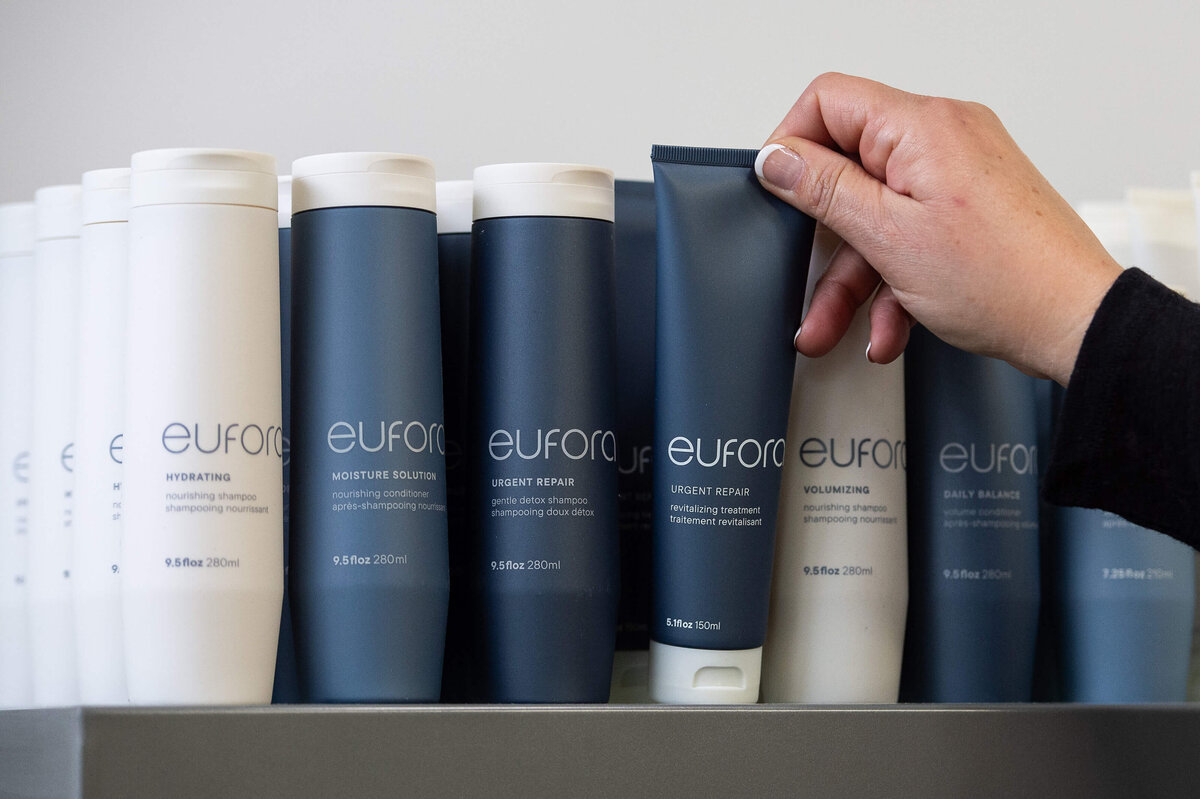 Ottawa branding photography showing a hand reaching for Eufora hair products on a shelf