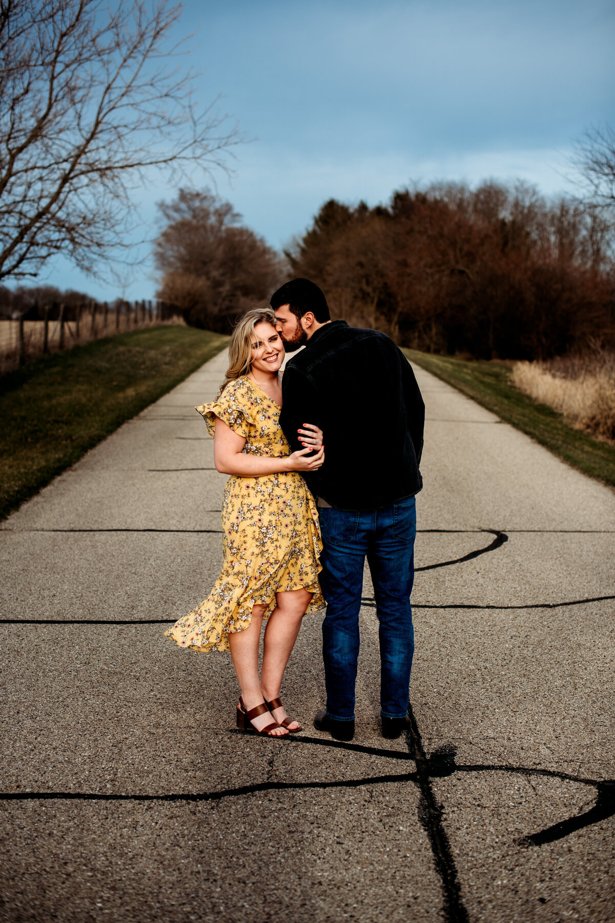 Man kisses woman on the side of the head while she smiles