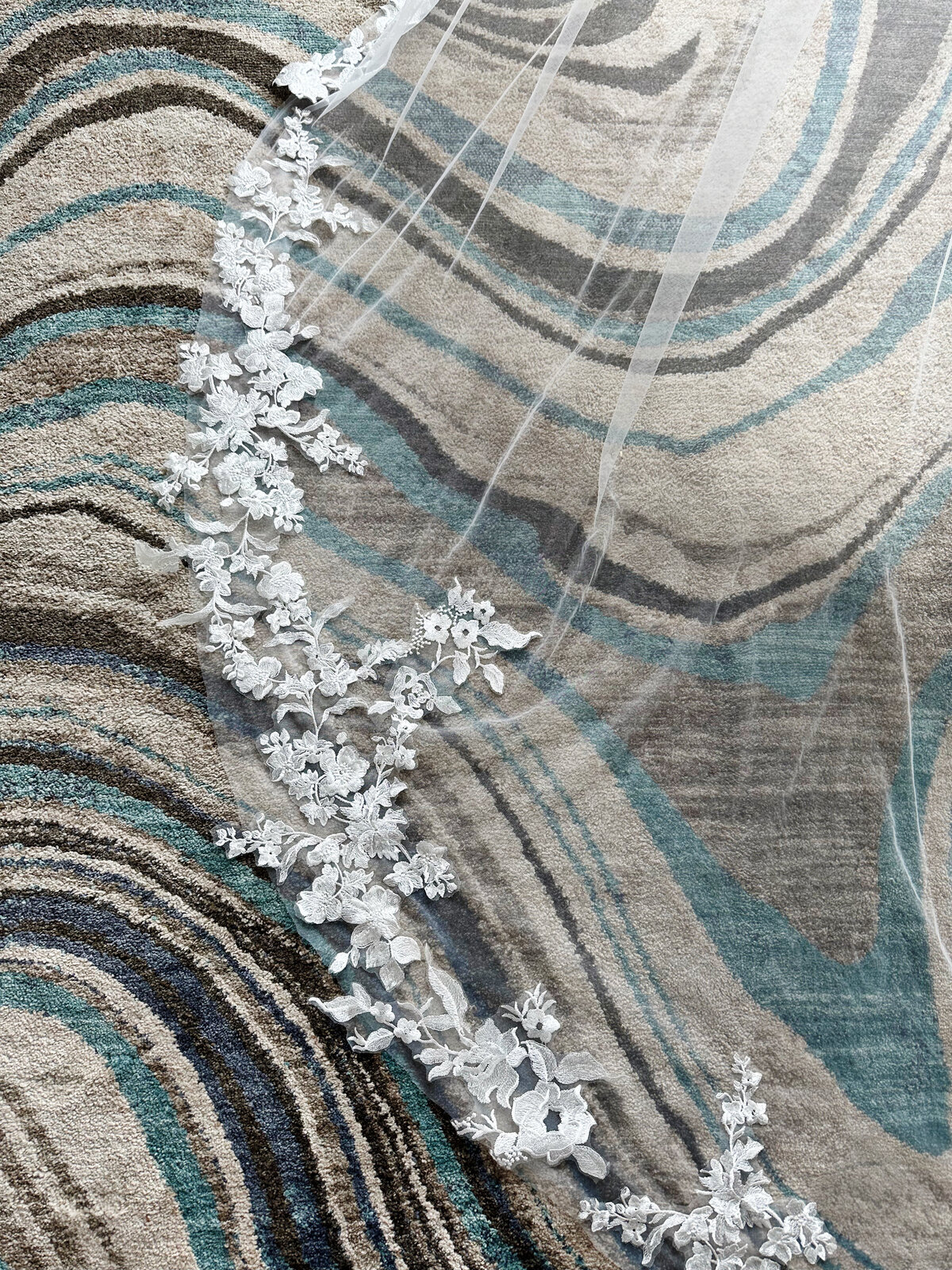 Bride lifting lace-edge blusher veil during wedding ceremony
