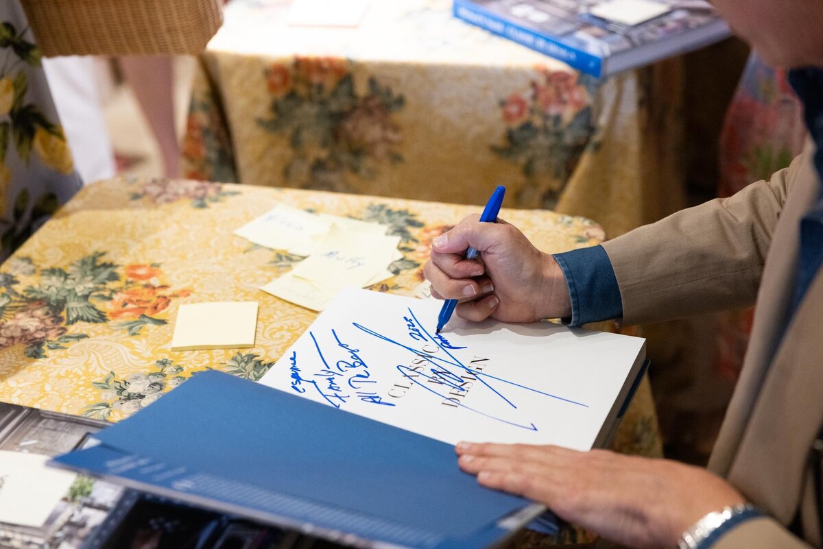Close-up of a guest signing a book during the event.