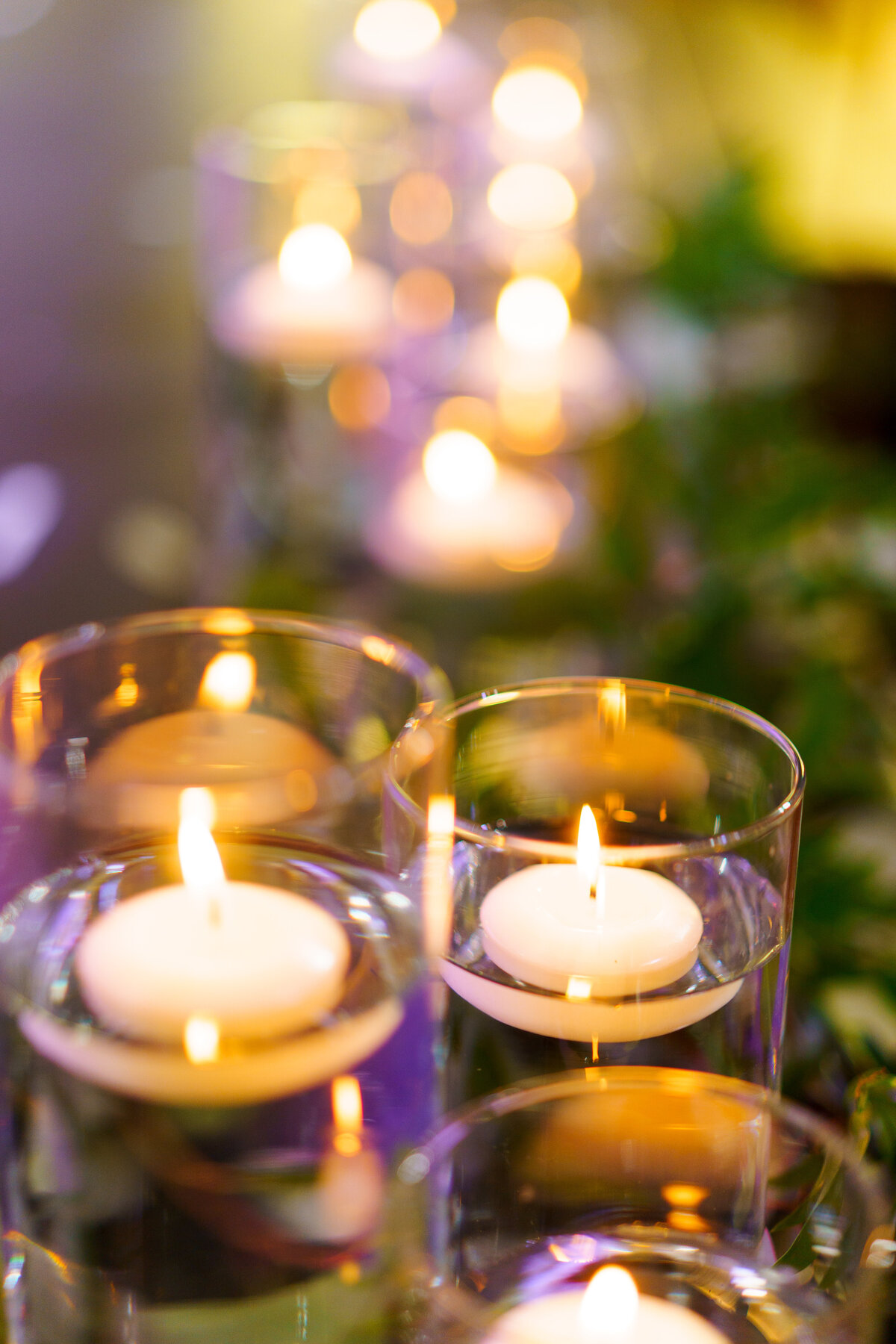 Floating candles amidst greenery and purple lighting at a wedding at 1883 Locale in Reynoldsburg, Ohio.