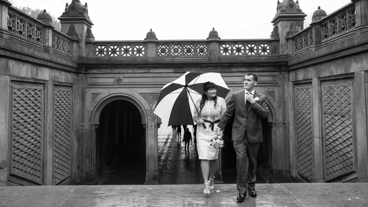 Black and white photo of a wedding couple walking together.