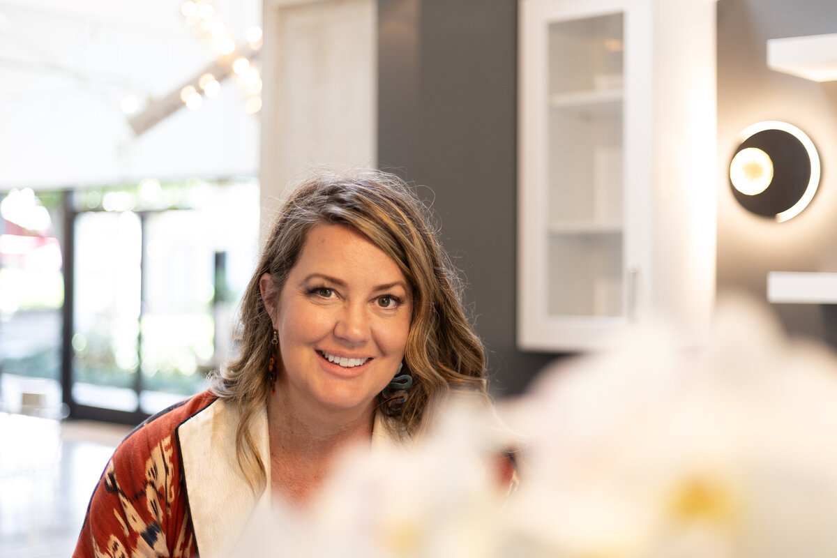 Beth Burnett smiling at camera with flowers in foreground