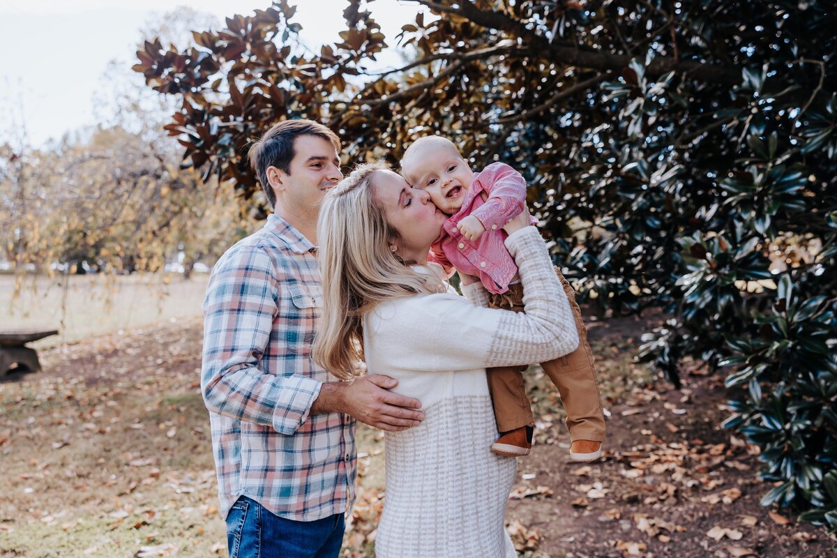 Nashville family photographers capture mother lifting son and kissing his cheek
