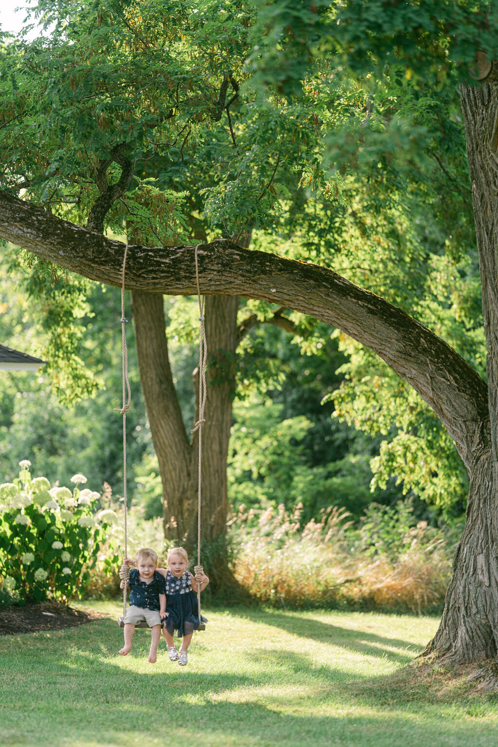 two-kids-outdoor-tree-swing-windridge-estate