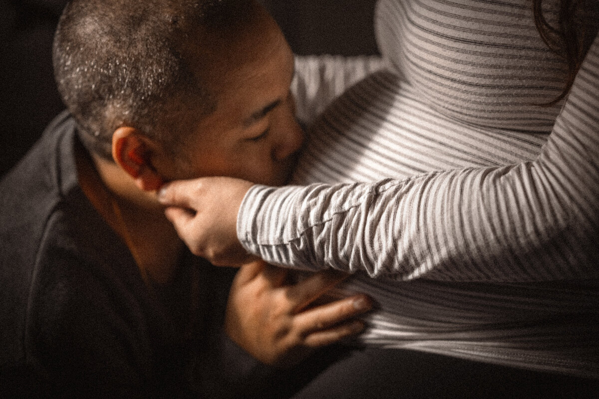 husband kissing pregnant wife belly