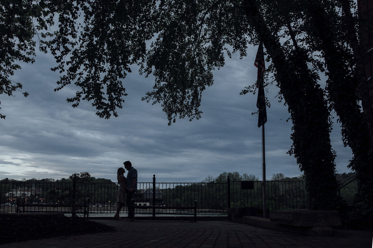 Couple in silhouette during engagement session by Delaware River in New Hope Pennsylvania