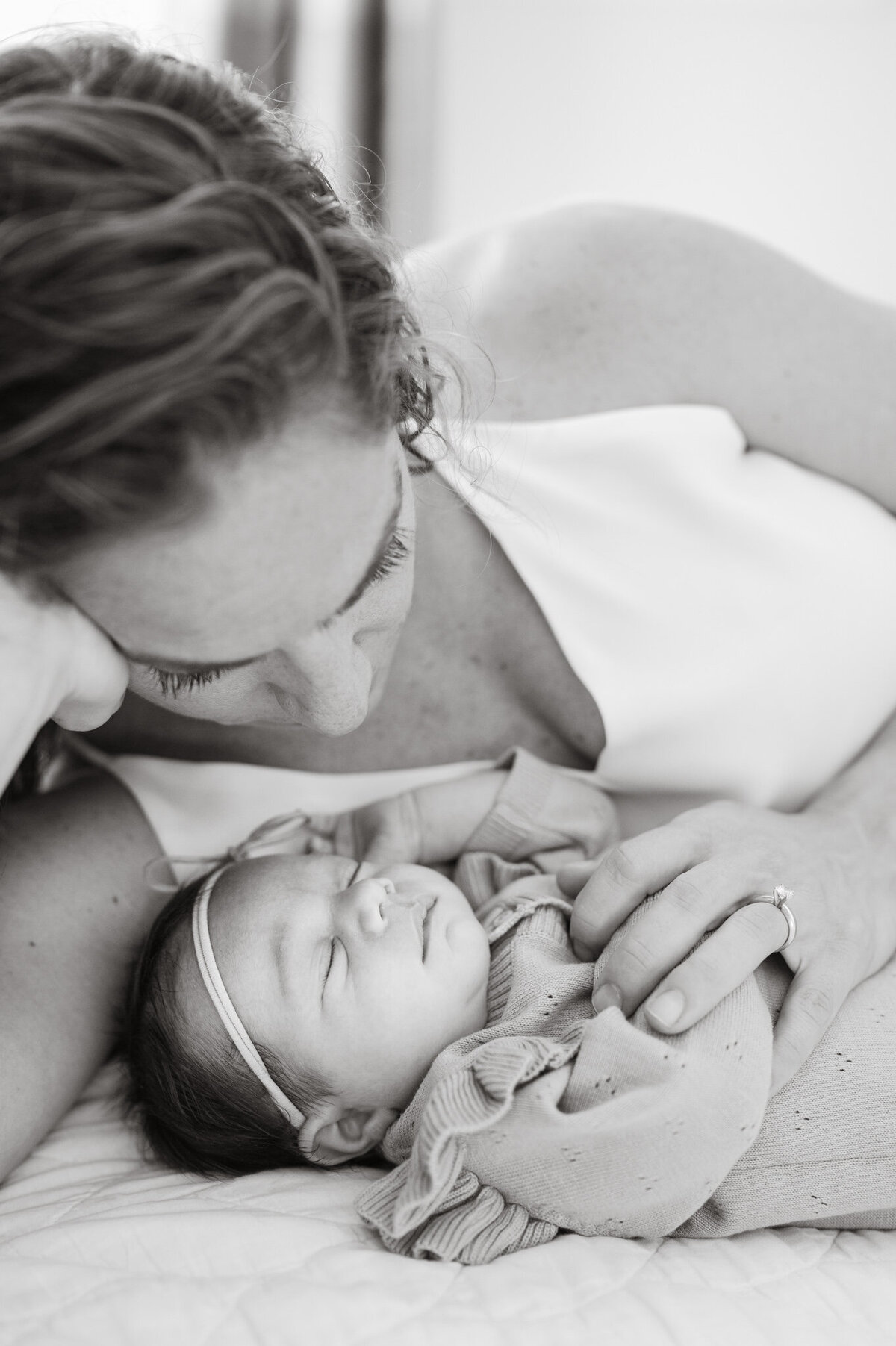 Black and white portrait of mom gazing down at baby daughter. Images by San Antonio Newborn Photographer Cassey Golden.