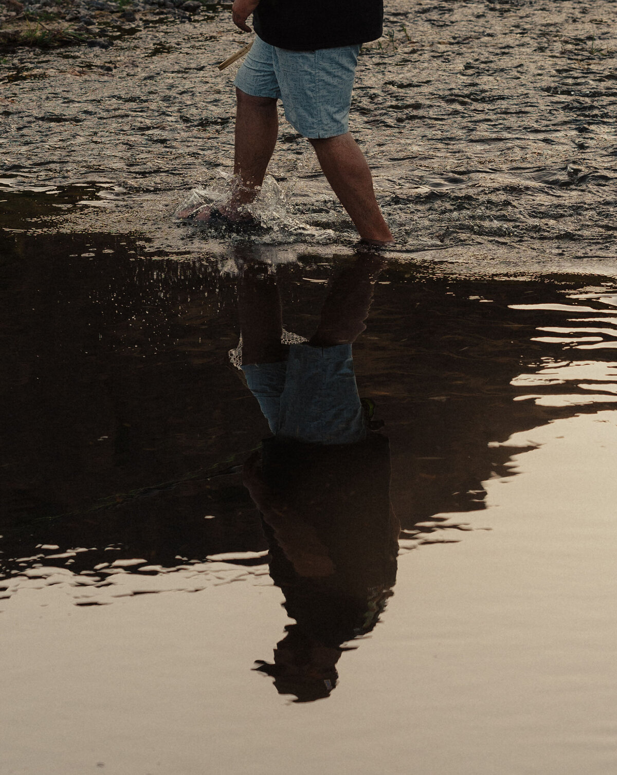 a man walks through the river during sunset in Moab, Utah on his way to an elopement