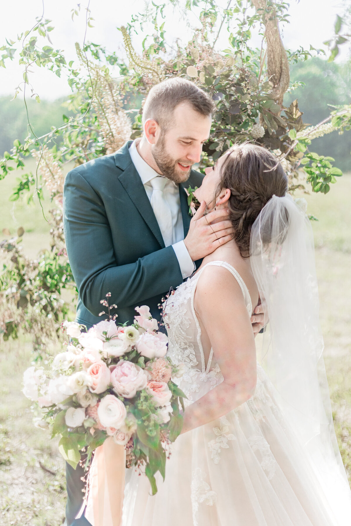 A groom brings his bride in for a kiss