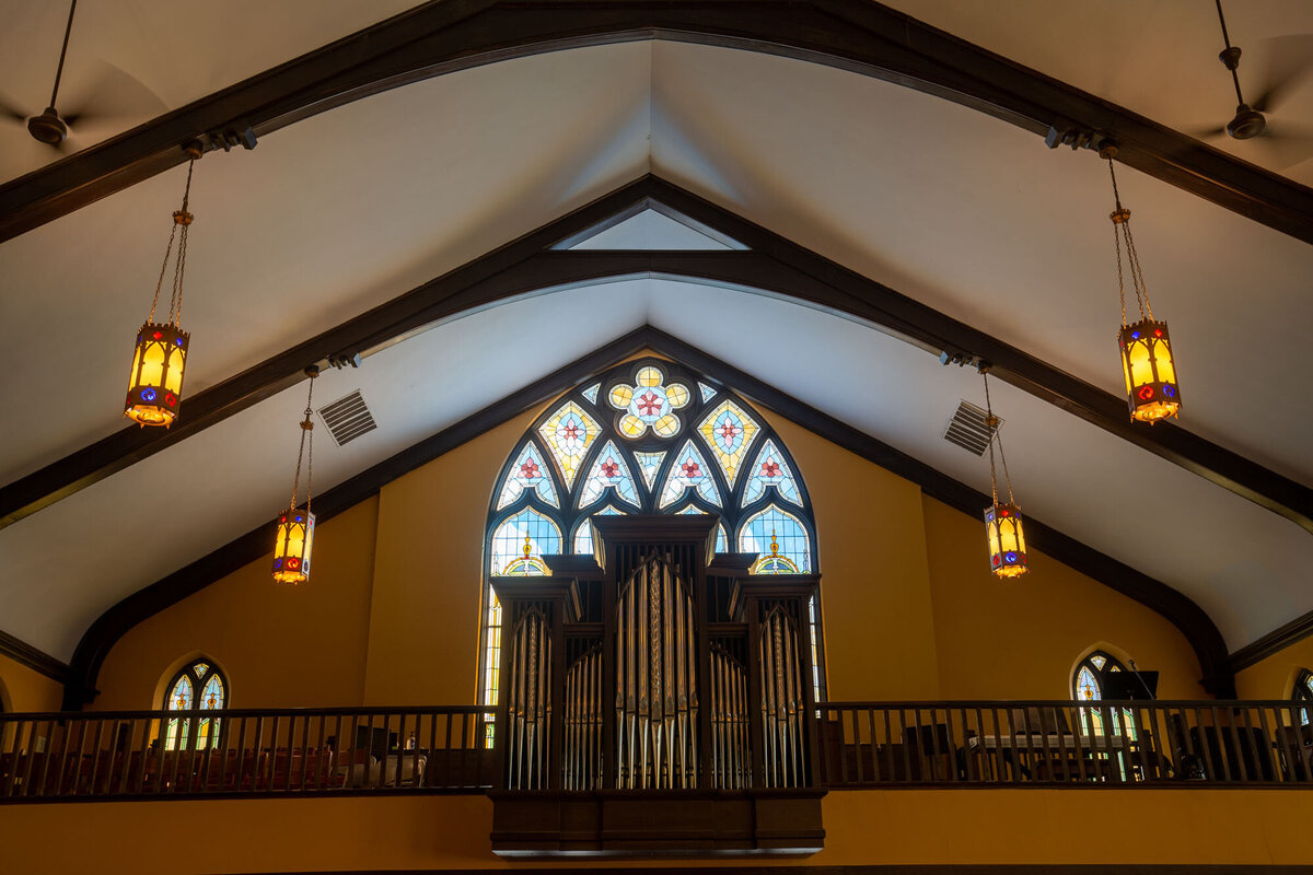 A church with a stained glass window and an organ