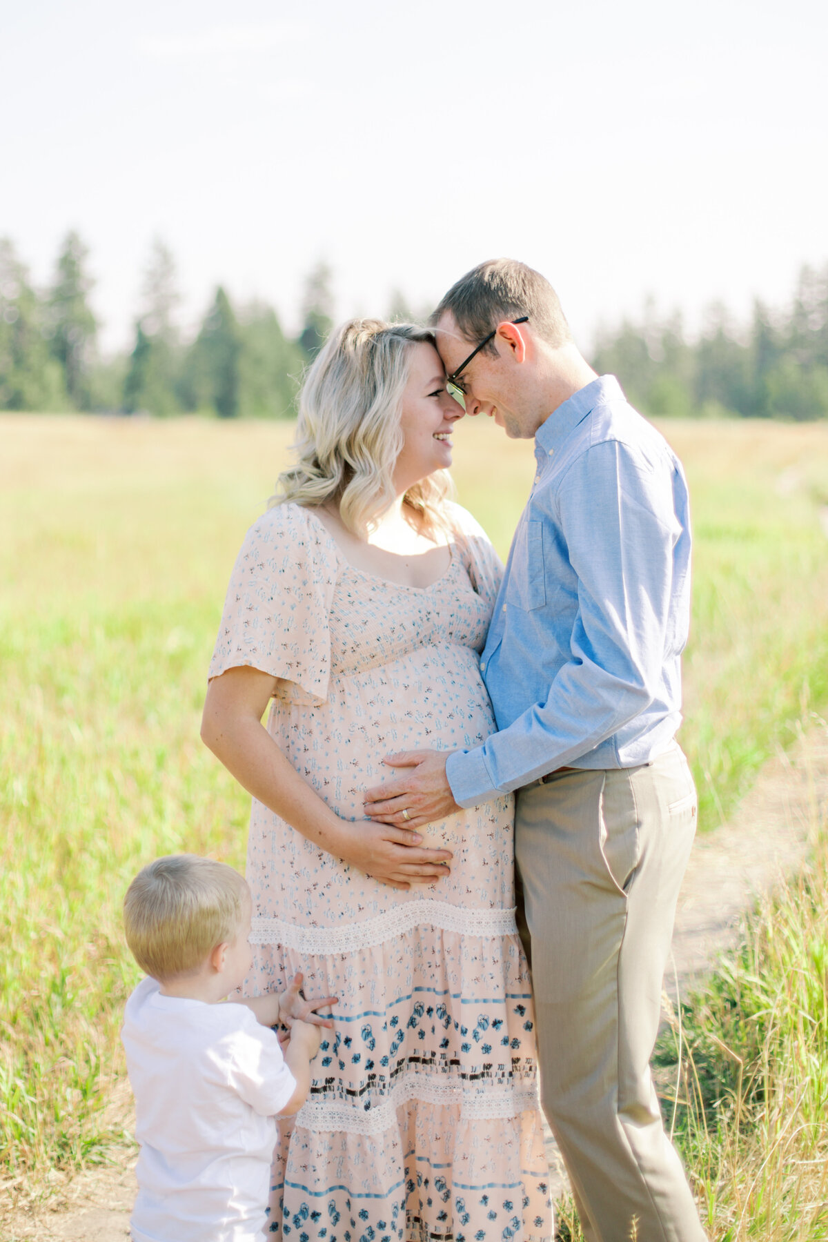 couple touching foreheads and son in frame taken by maternity photographers spokane
