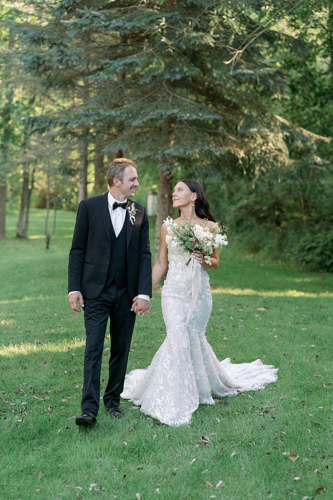Newly married couple walking through the garden at Glasshouse Community during their intimate outdoor Michigan wedding.