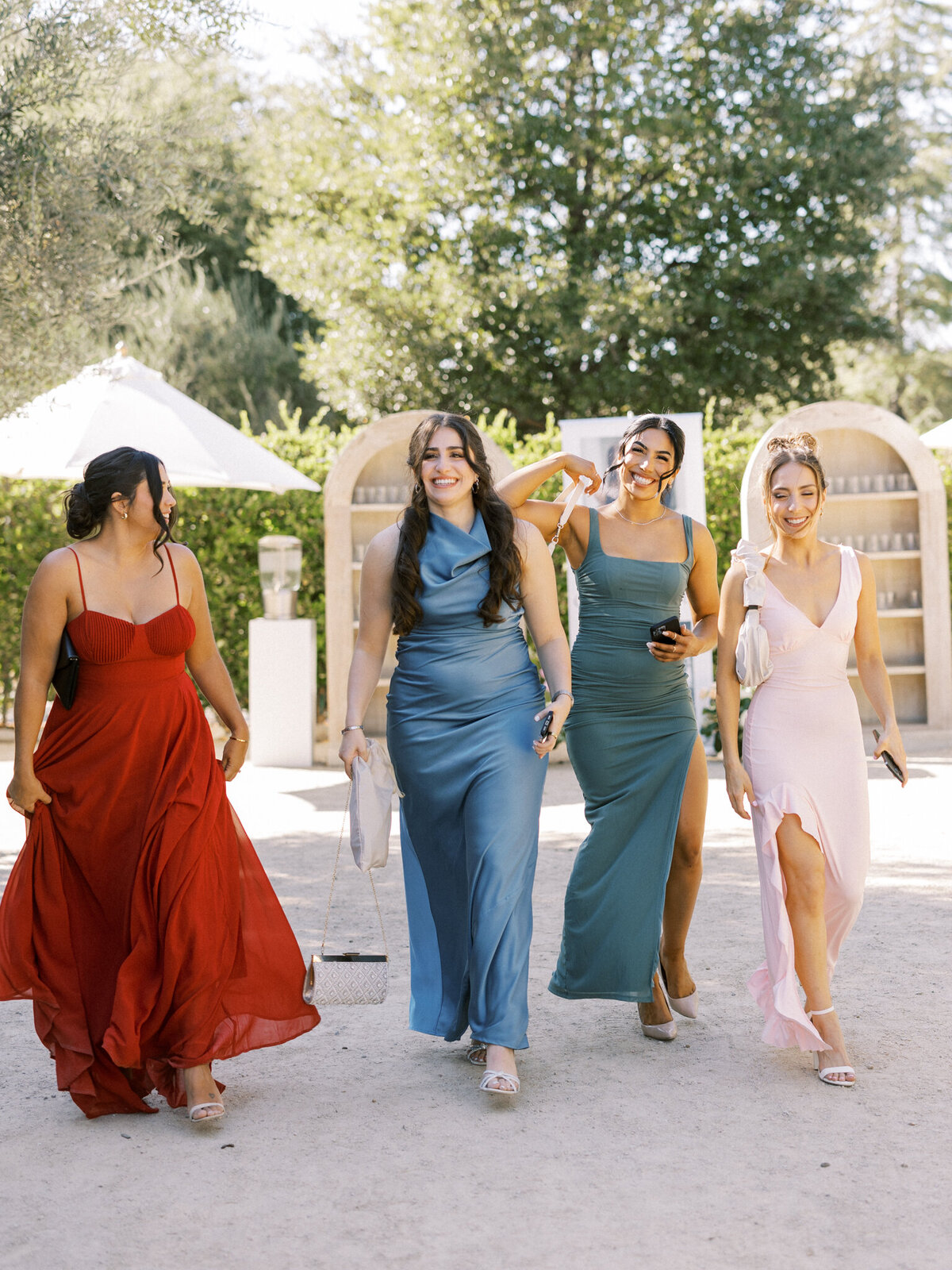 Chic wedding guests in colorful dresses arriving in style—playful elegance at a sun-soaked vineyard celebration.