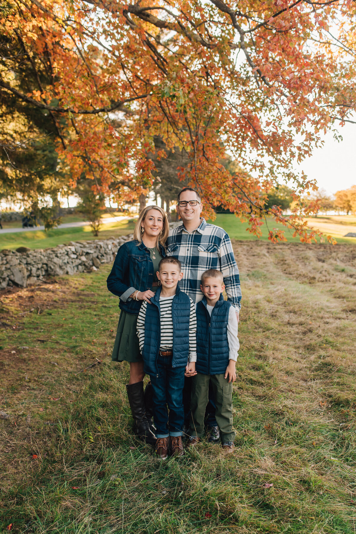 Family of four smiling at the camera at Topsmead State Forest in Litchfield, Connecticut