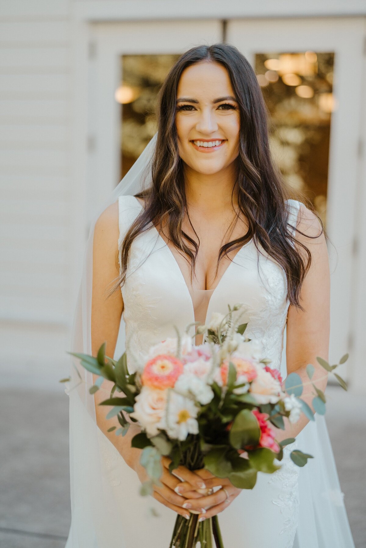 a portrait of a bride in her dress holding a flower bouquet