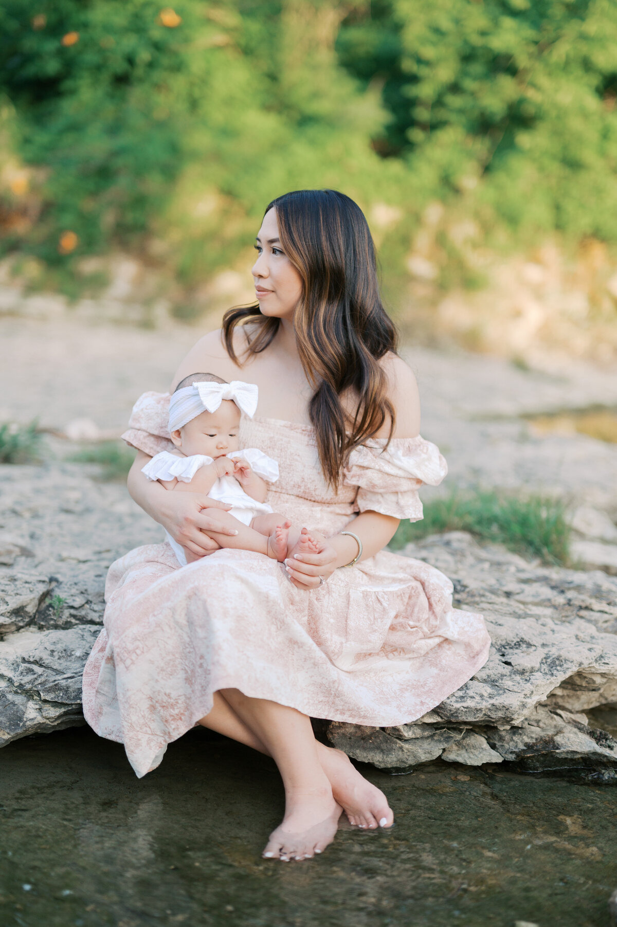 mom holds newborn baby creekside in north fort worth