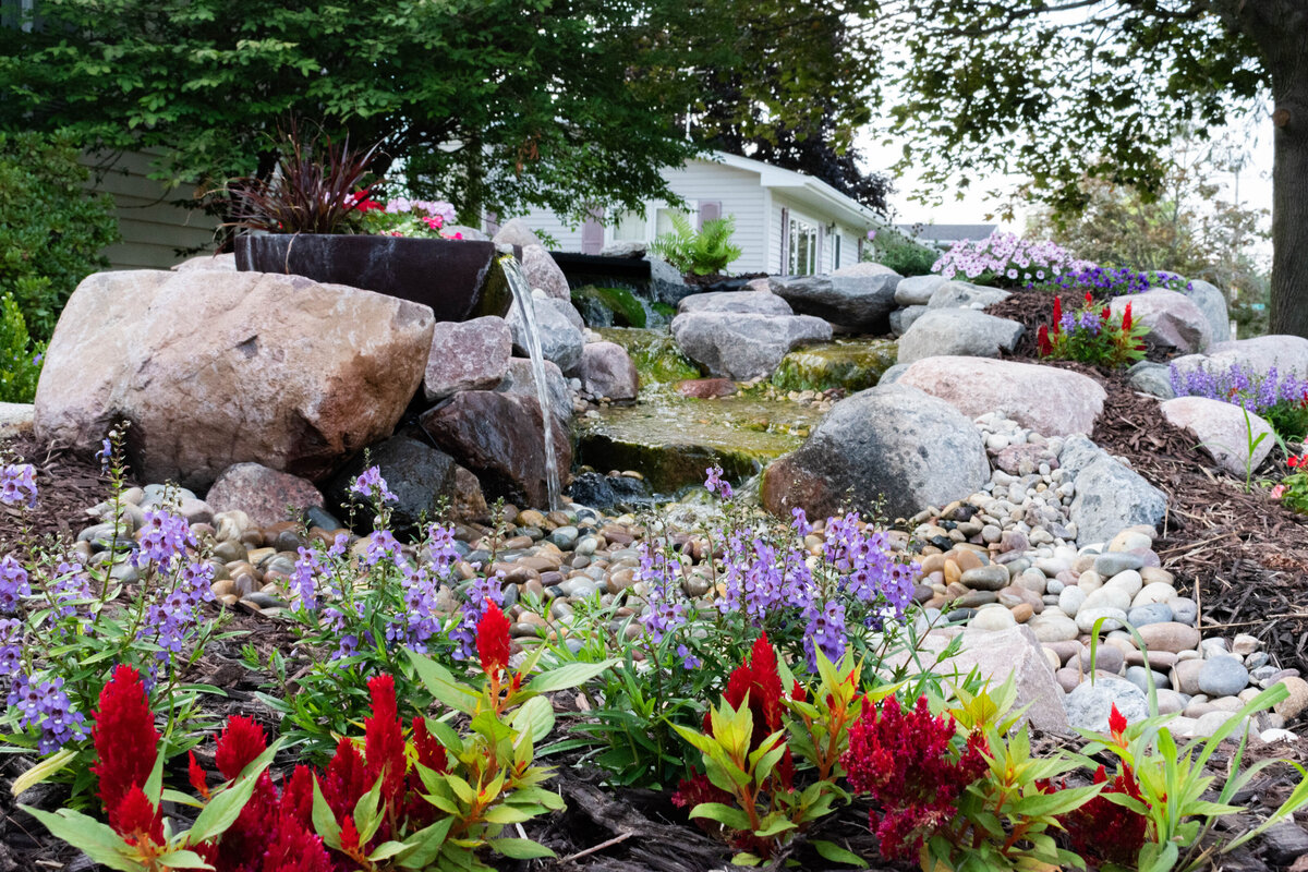 Flowing waterfall with colorful flowers and landscaping