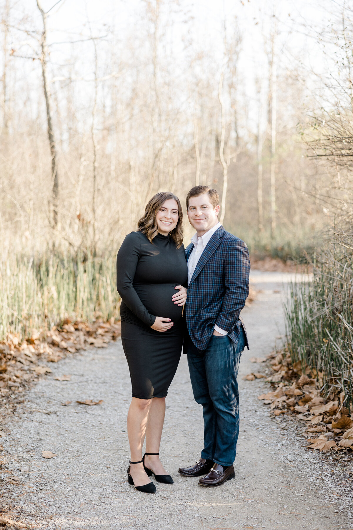 expecting parents smiling at the camera during maternity session