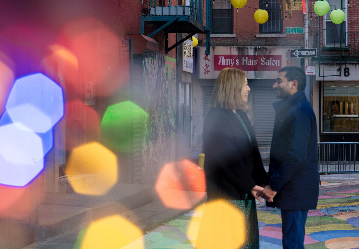engaged-couple-with-bokeh-lights-in-forefront