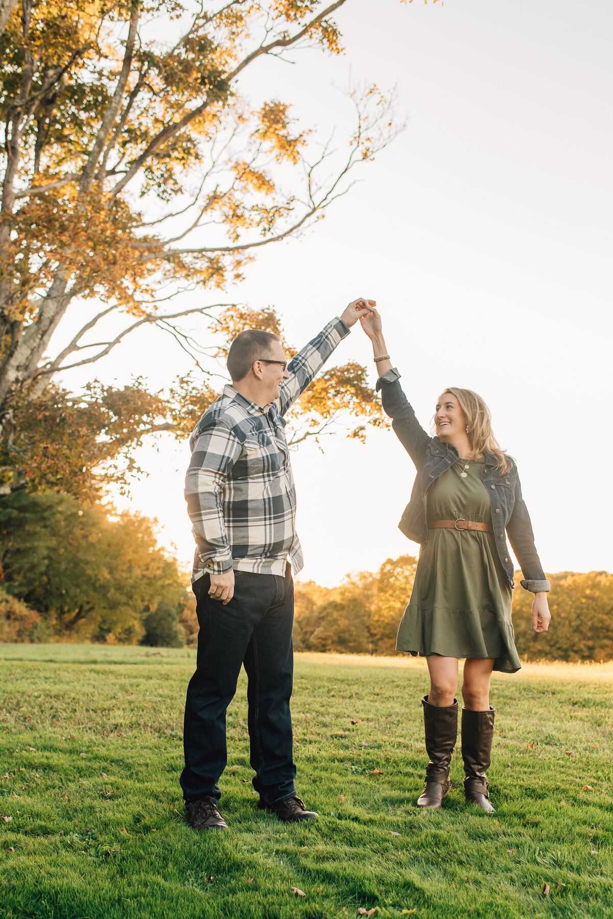 Parents smiling at each other in field at sunset in Litchfield, Connecticut