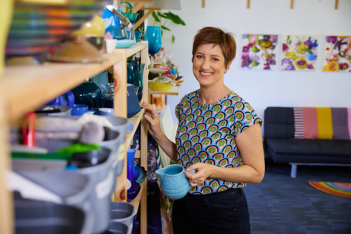 Woman in small business holding product