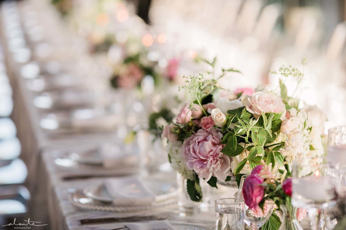 Long dinner reception tables lined with small blush and green floral