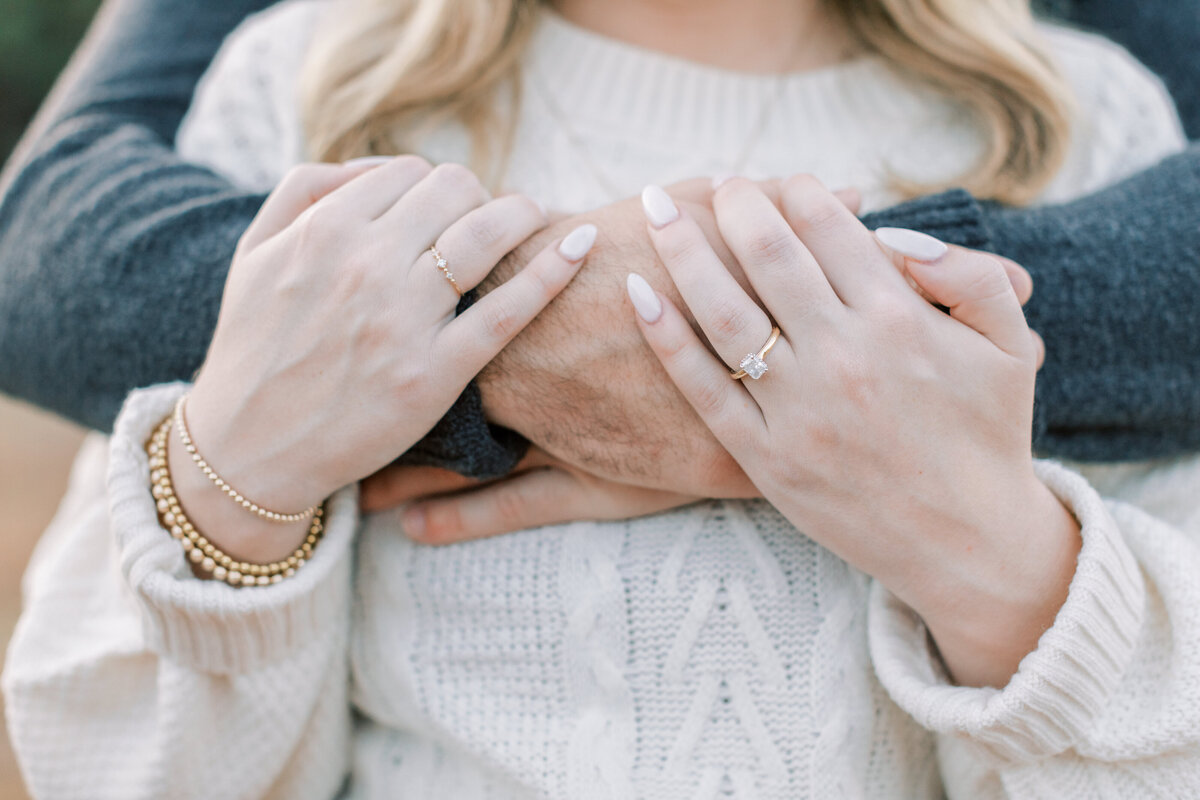 A couple hugs each other while wearing sweaters.