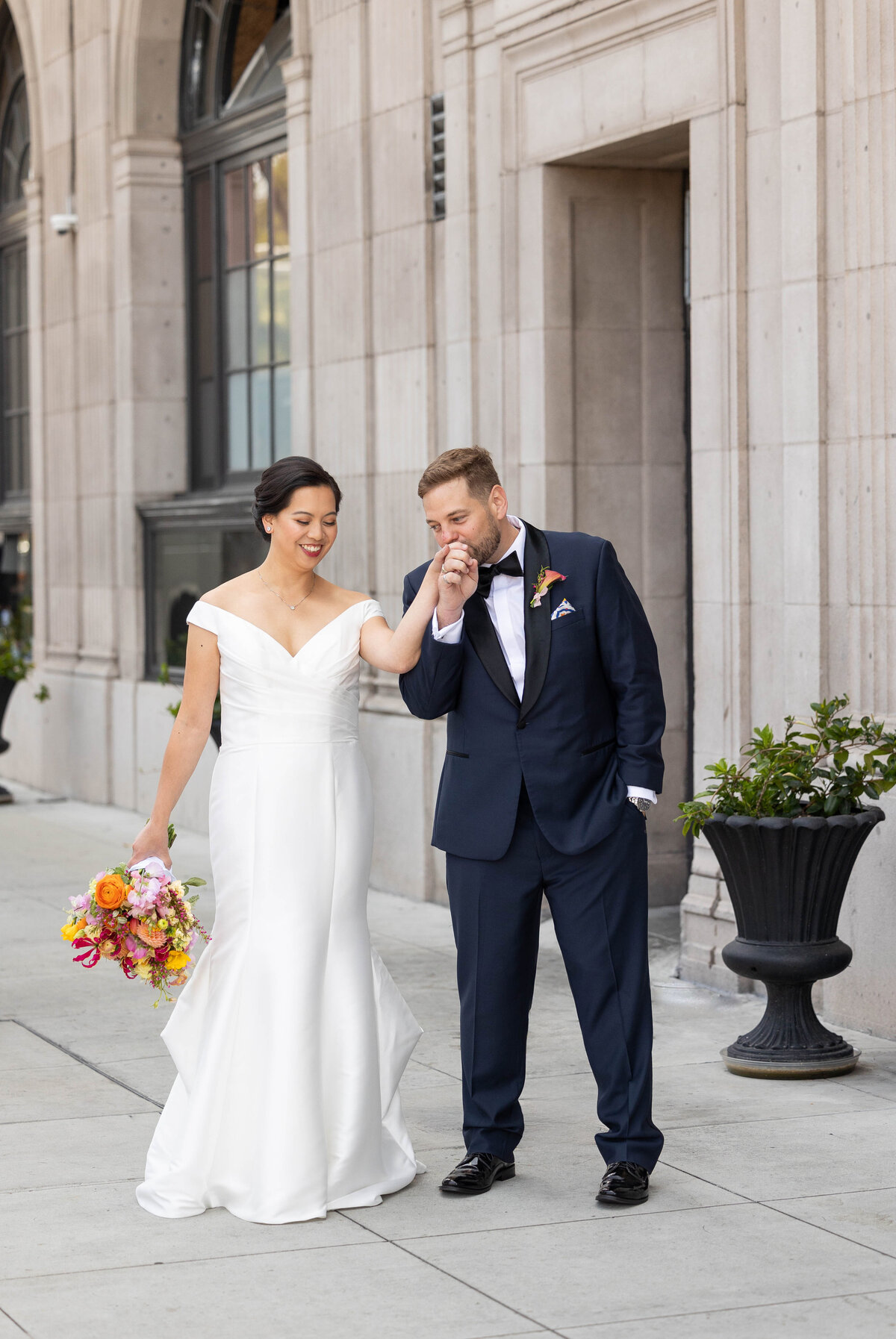 Groom kissing brides hand