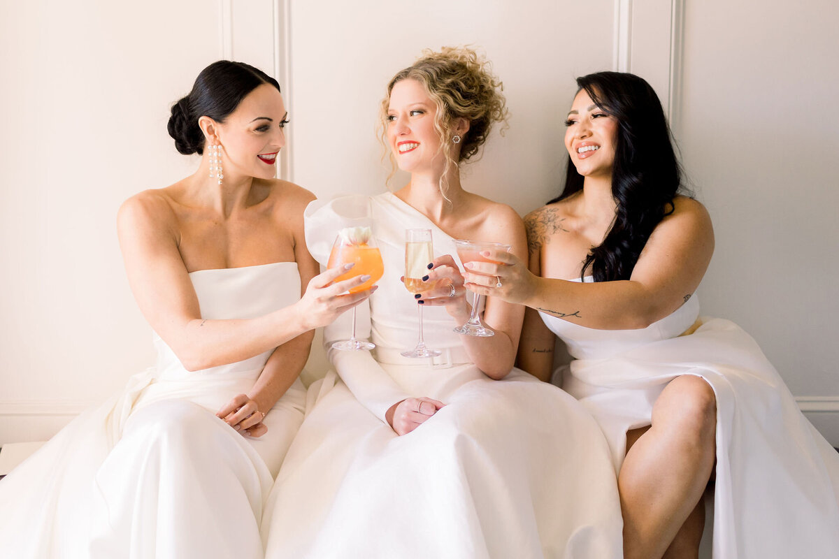 brides clinking glasses of champagne