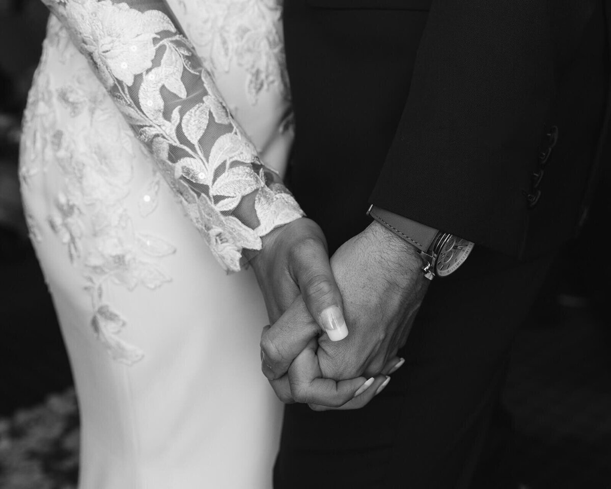 The hands of a couple with interlocked fingers
