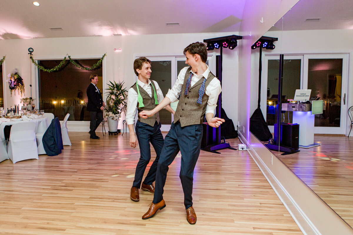 Two grooms dance together on the dance floor during their wedding in Boone, NC