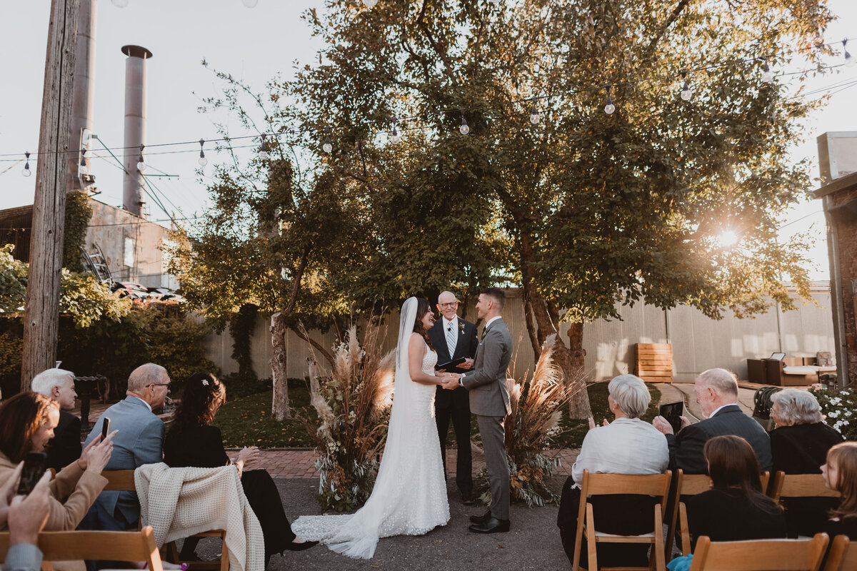 Bride and groom in front of the trees at Blanc Denver for their wedding ceremony.
