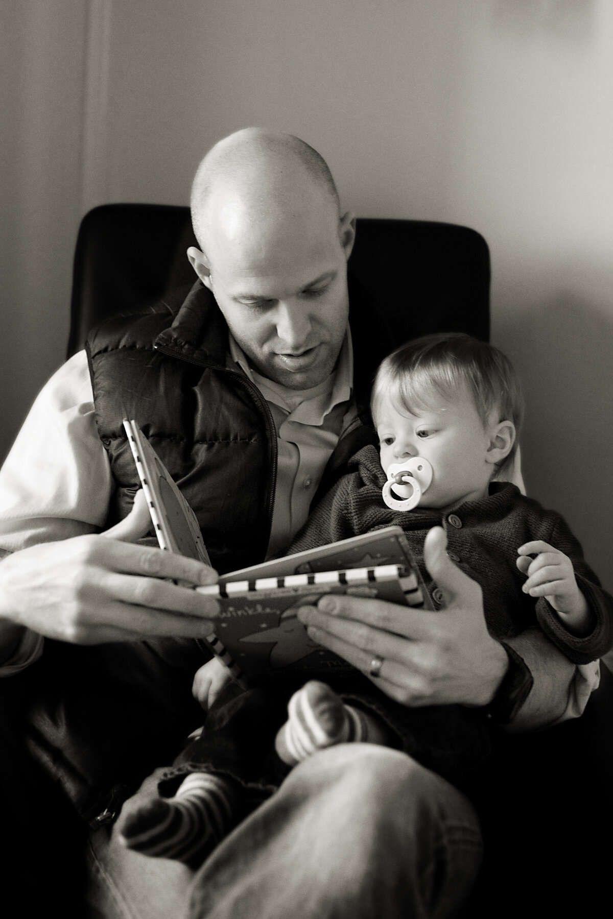 A parent holding their baby and reading to them 