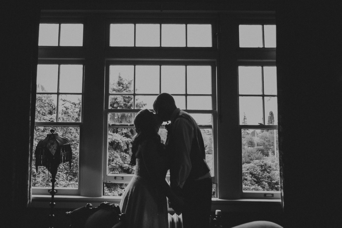 black and white photo of bride & groom kissing inside the McMenamins Grand Lodge in Forest Grove, OR | Susie Moreno Photography