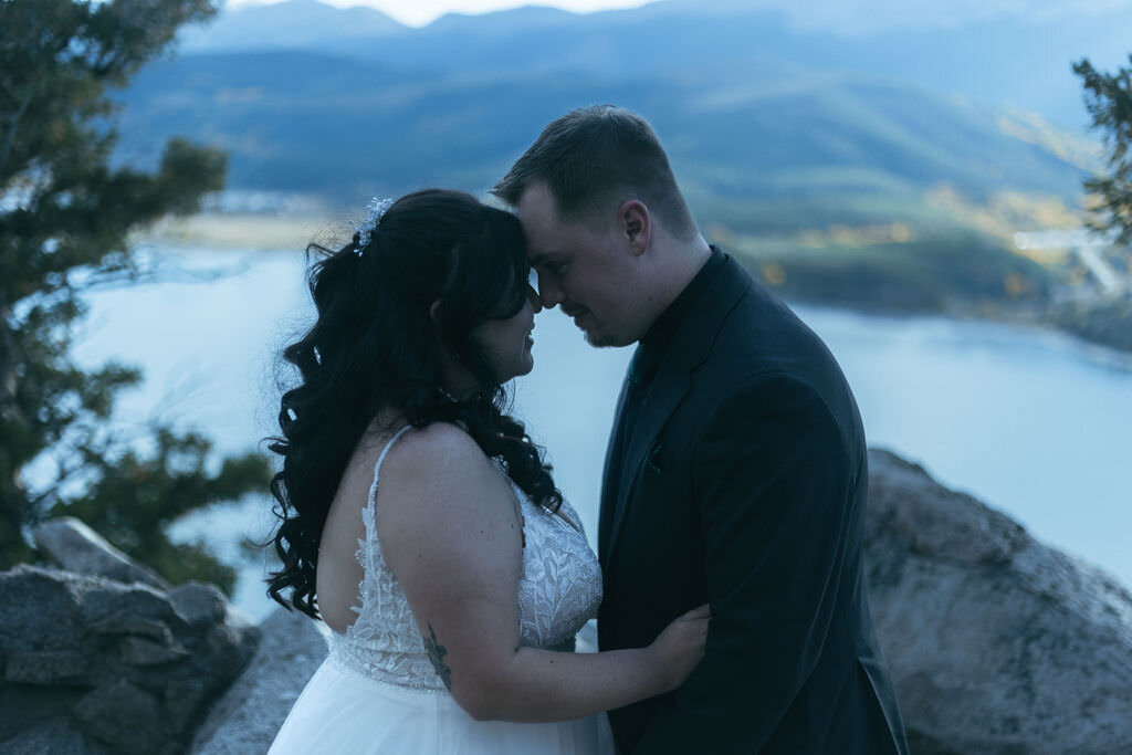 A newlywed couple with their foreheads together.