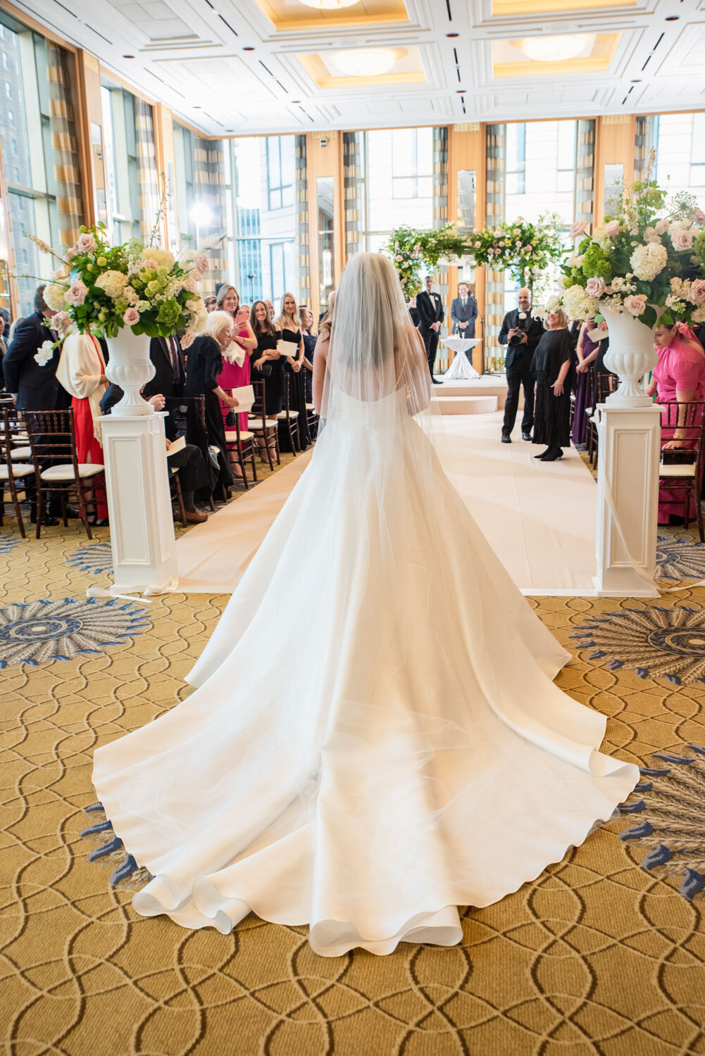 A bride in a wedding dress is walking down the aisle