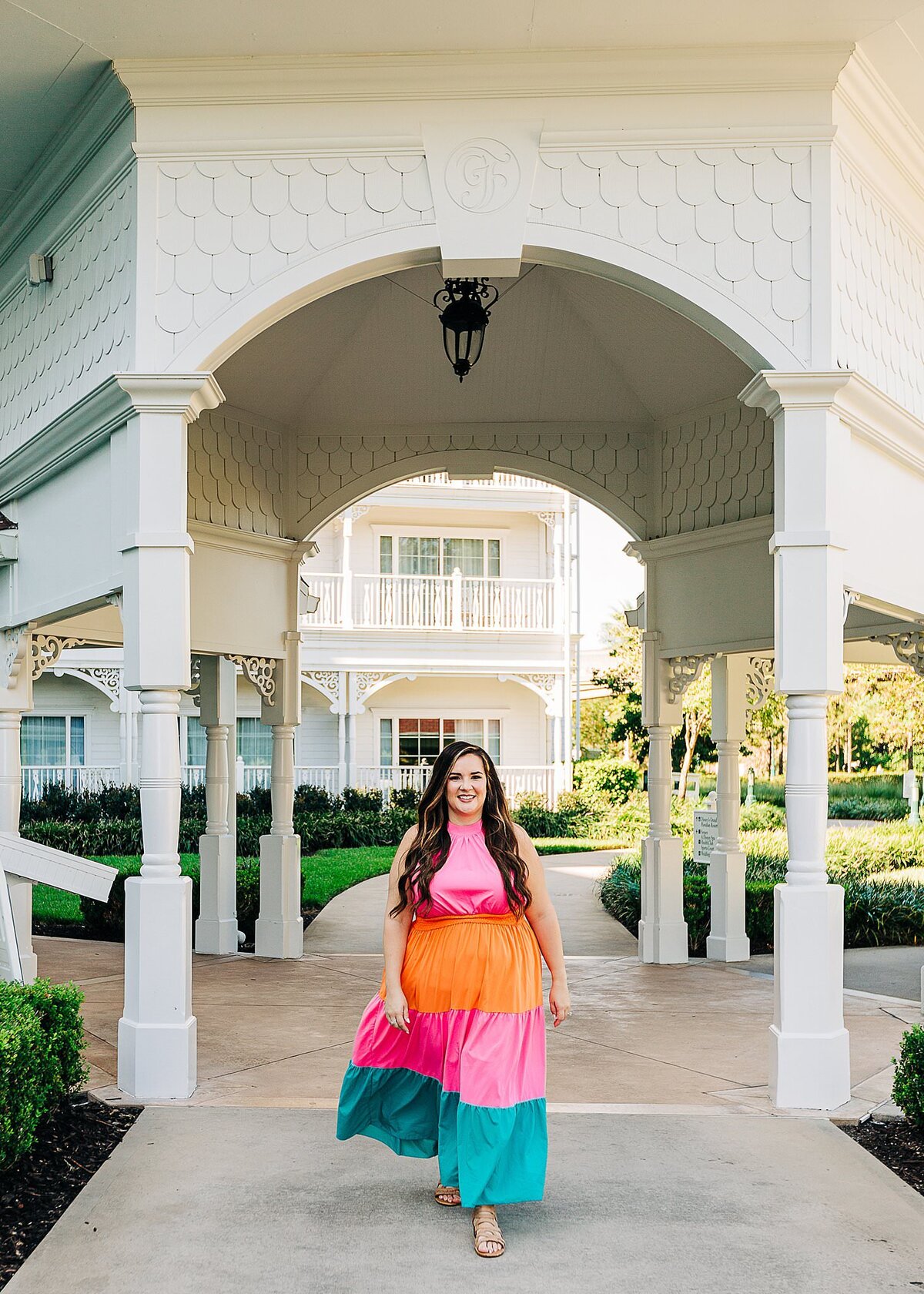 Woman walking with flowy colorful dress from and arc in Disney's Grand Floridian Resort